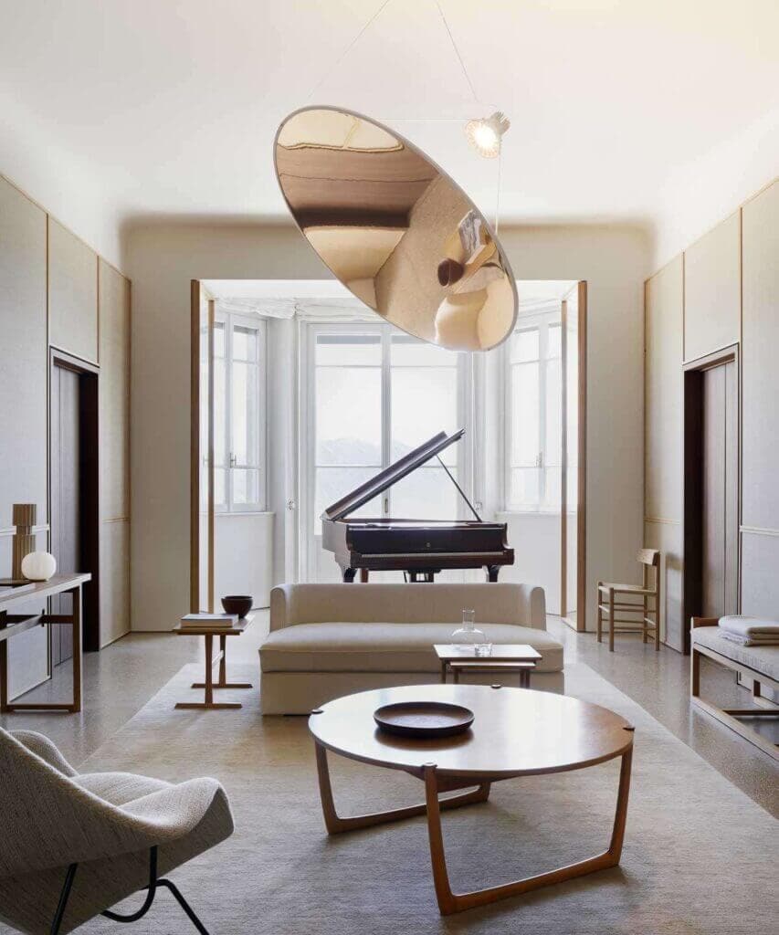 Luceplan Amisol pendant in gold above a living room with a piano
