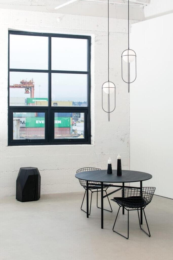 A-N-D Light Orbit pendant, wire cage fixtures above a dining table near a window
