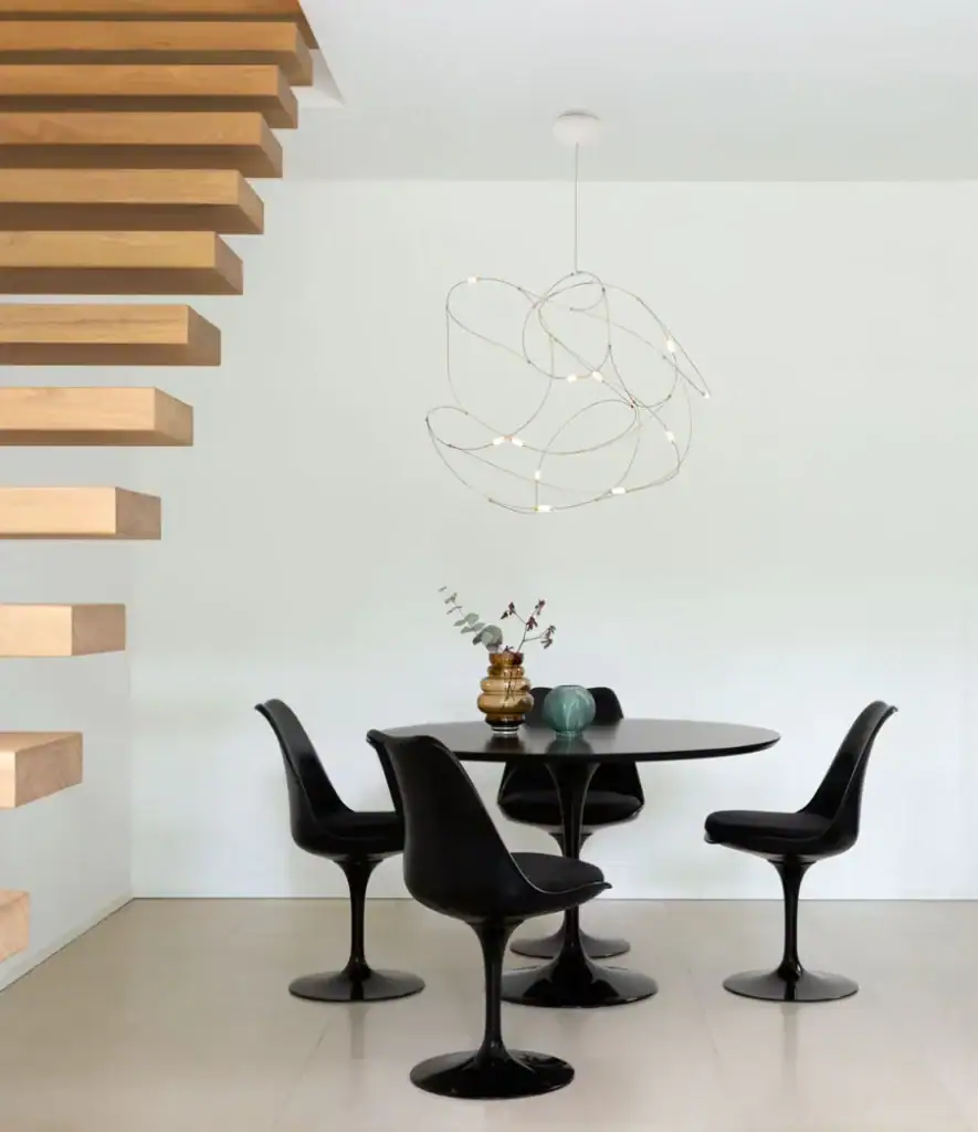 Moooi Flock of Light pendant above a round dining table near a staircase