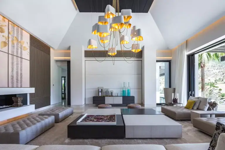 Designheure Nuage chandelier, white shades with gold interiors, above a living room seating area