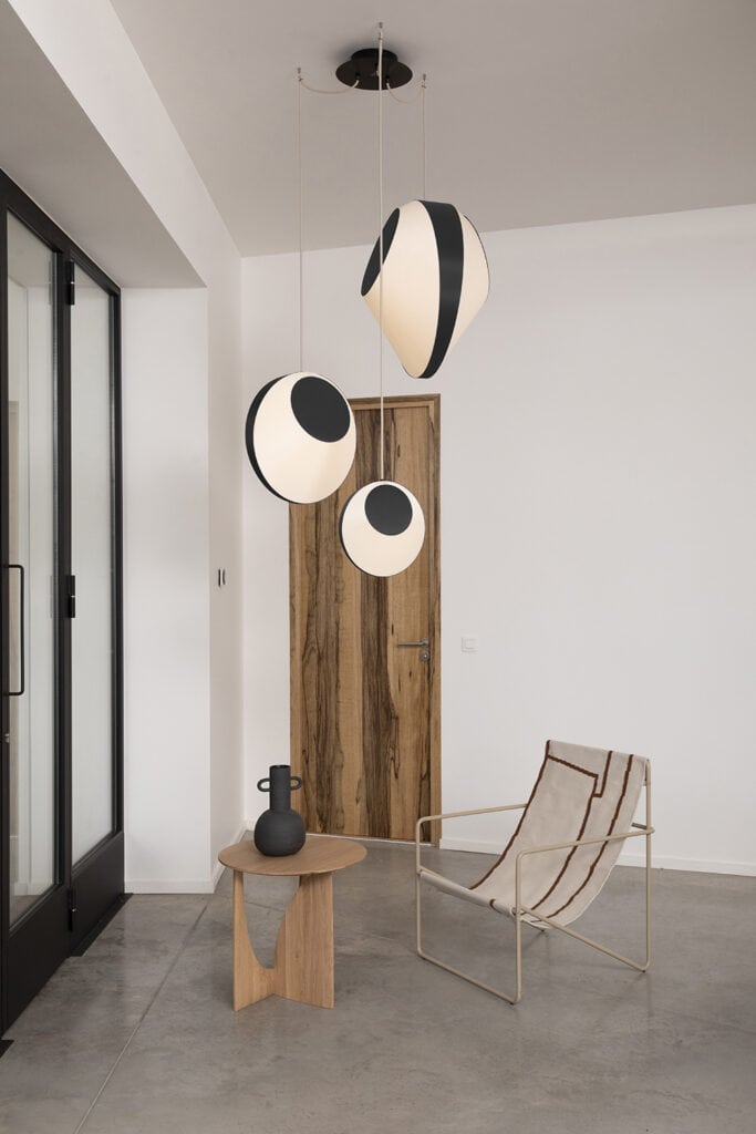 Designheure Reef pendant, two spherical shades near a wood cabinet