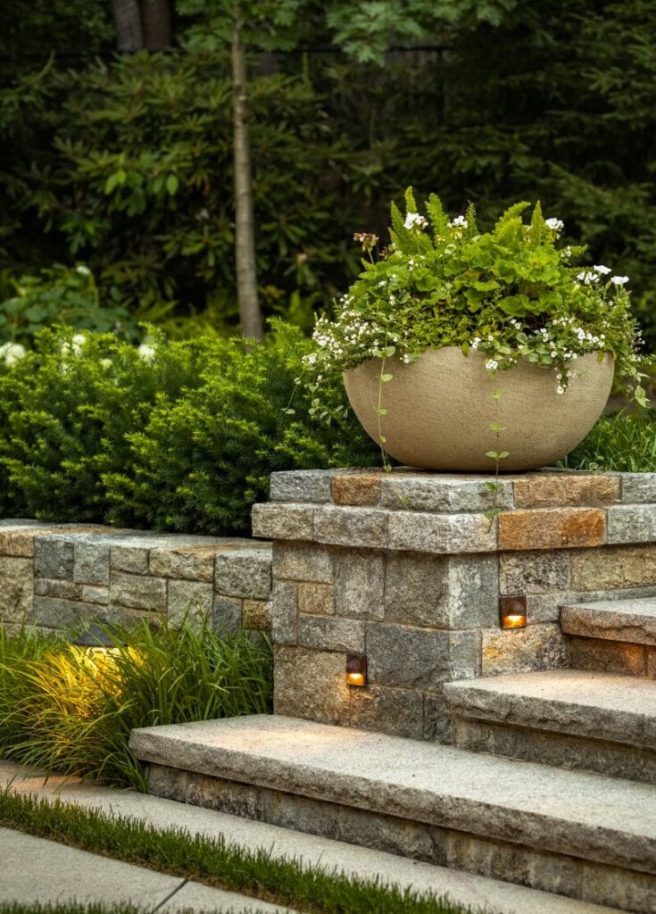 Hunza Step Light Eyelid, installed in a stone garden wall at dusk
