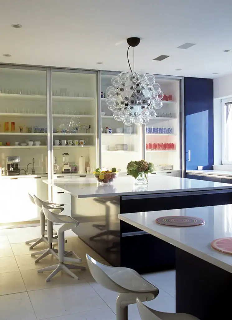 Flos Taraxacum 88 pendant, a sphere of clear bulbs, above a white kitchen island with stools