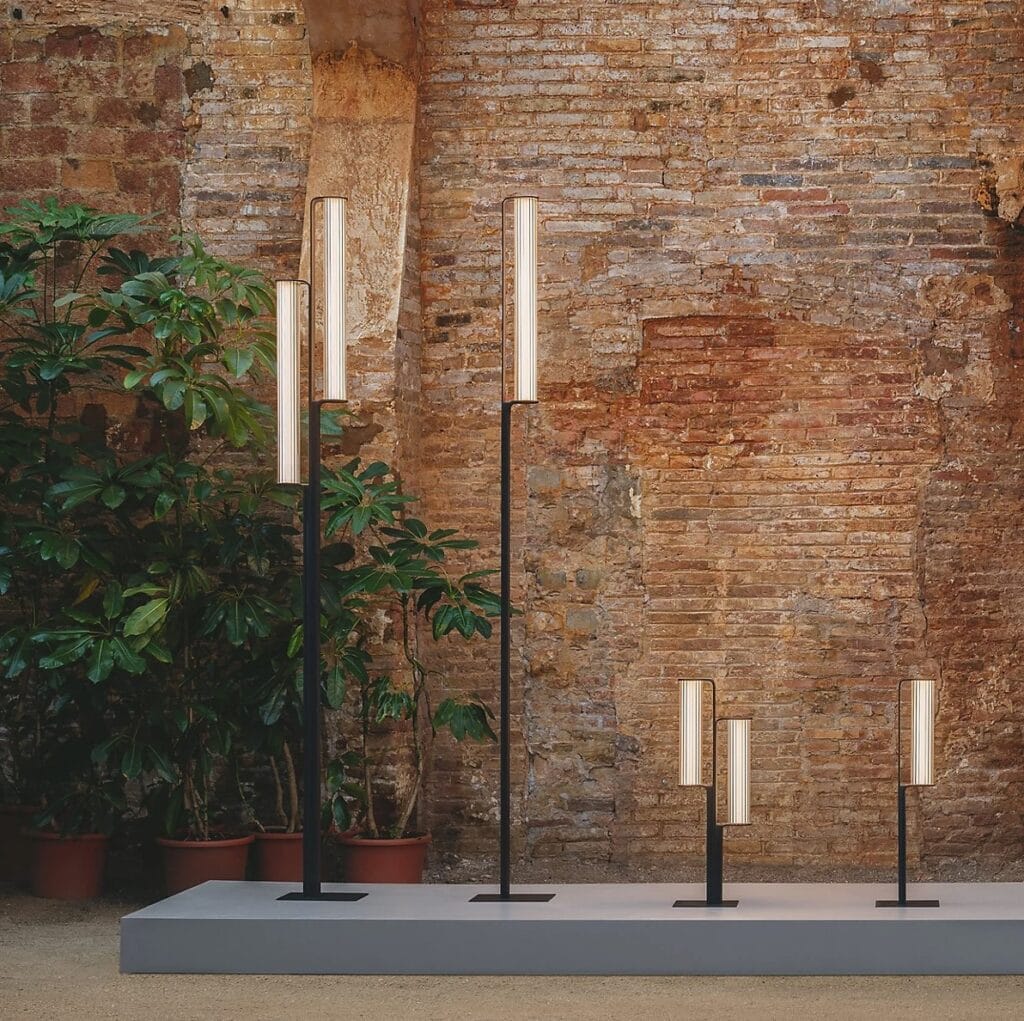 Class table and floor lamp, group of five in varying heights against a brick wall