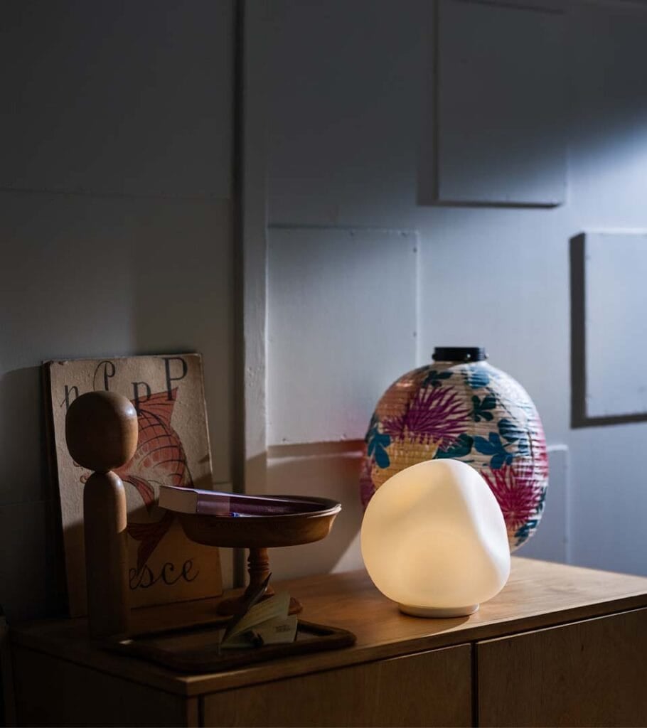 Foscarini Hoba table lamp, organic pebble shape lit on a sideboard