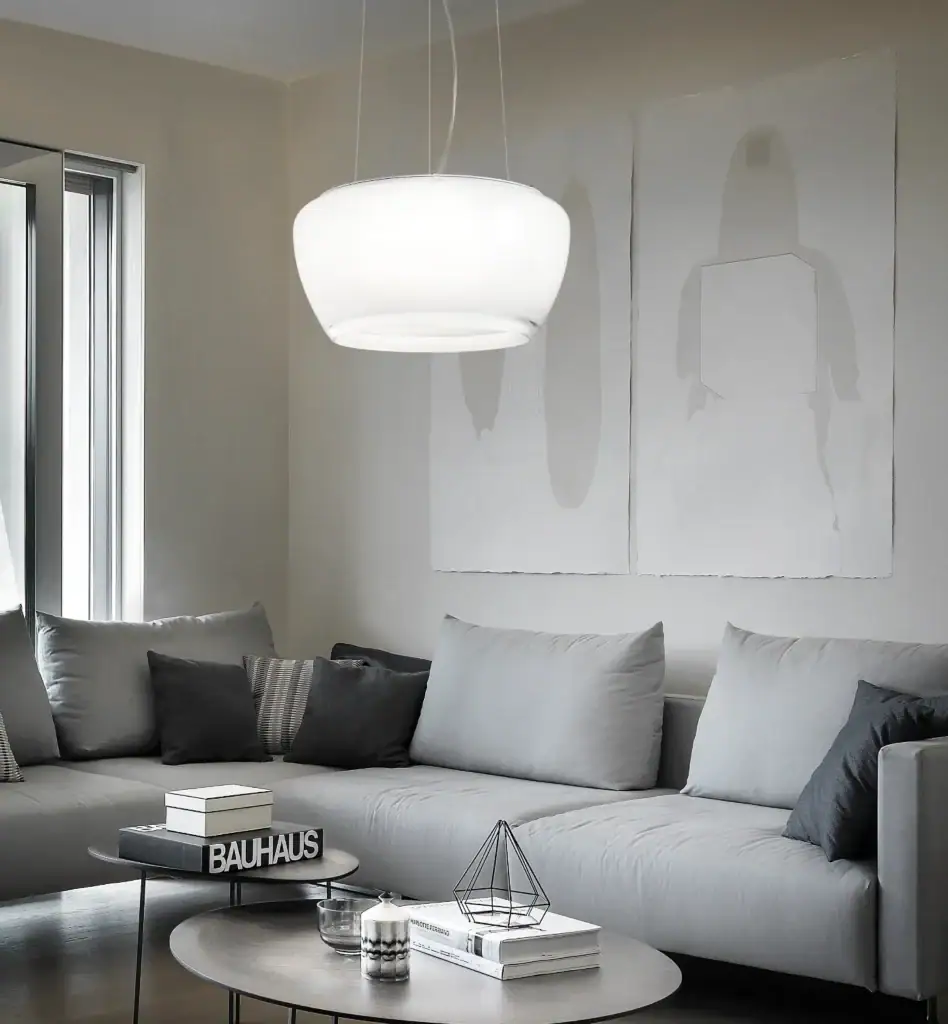 Vistosi Implode pendant in white glass, wide view above a living room sofa