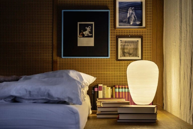 Foscarini Rituals table lamp, lit on a bedside stack of books