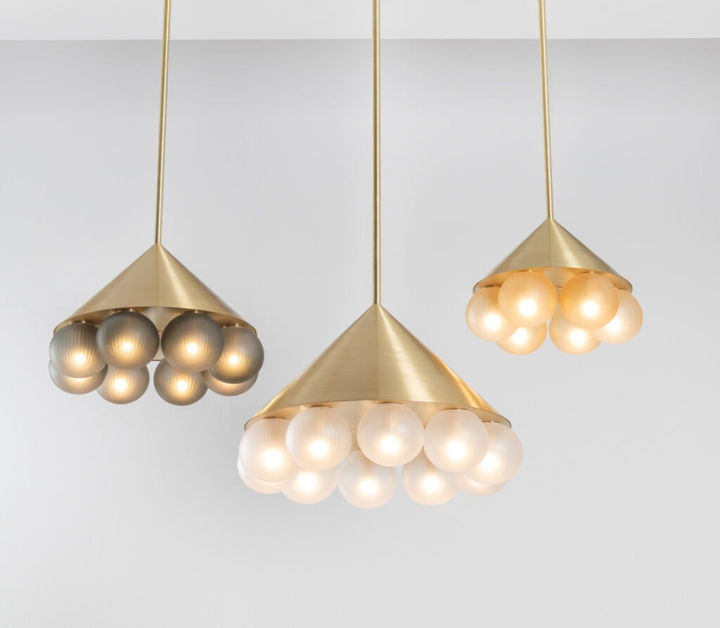 Modern pendant lights with gold finish and spherical bulbs.