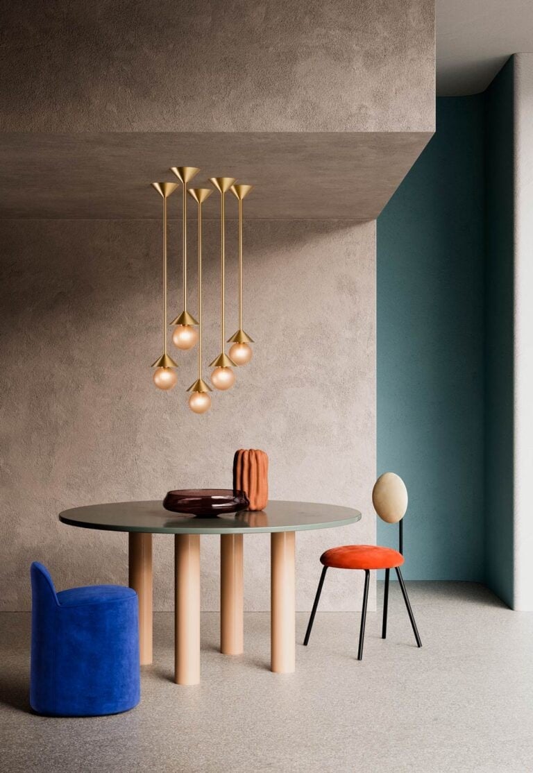 SkLO Peak pendants grouped at different heights above a round table, with a blue pouf and an orange chair