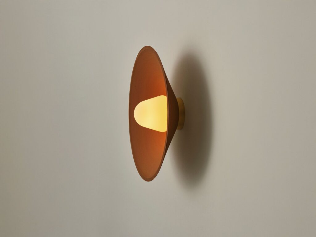 Modern wall sconce with warm glow and sleek design.