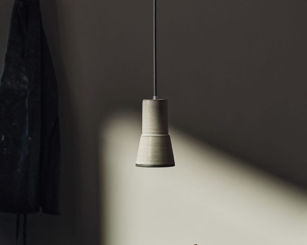 Modern pendant light fixture with a textured concrete finish.