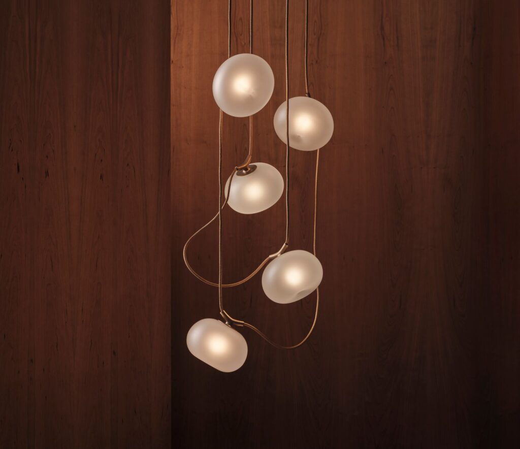 Modern pendant light with frosted glass globes and gold accents.