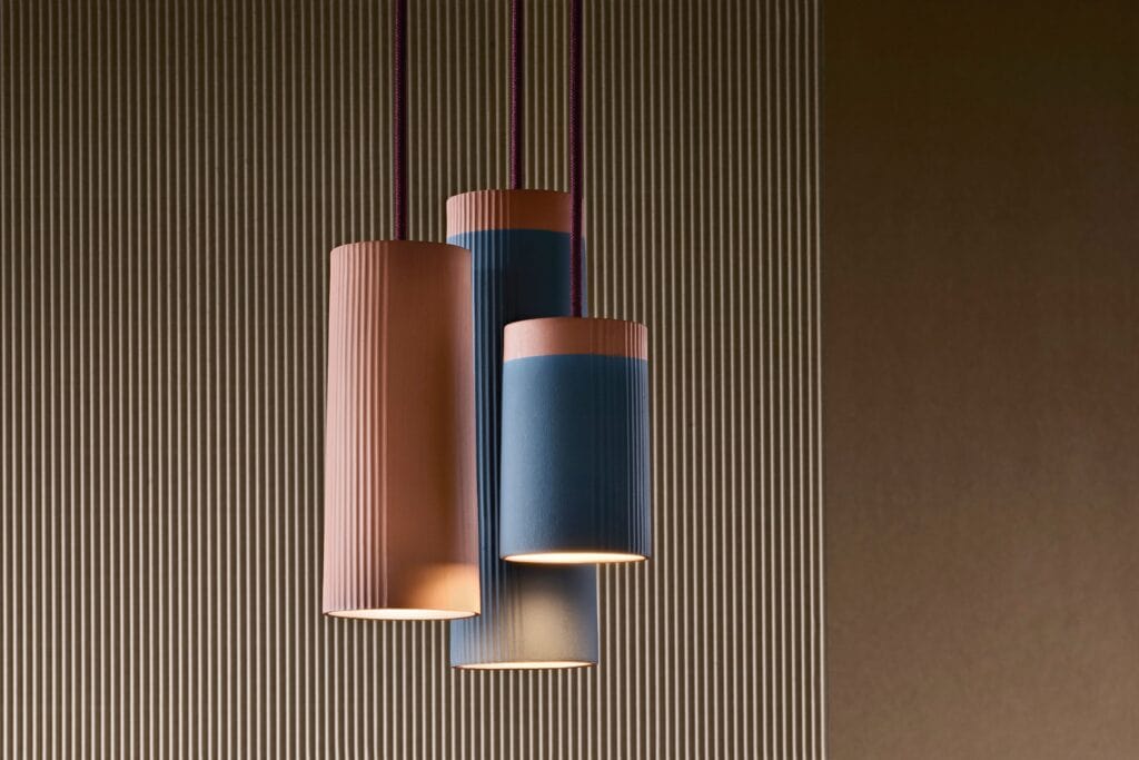 Modern pendant lights with pink and blue shades hanging from the ceiling.
