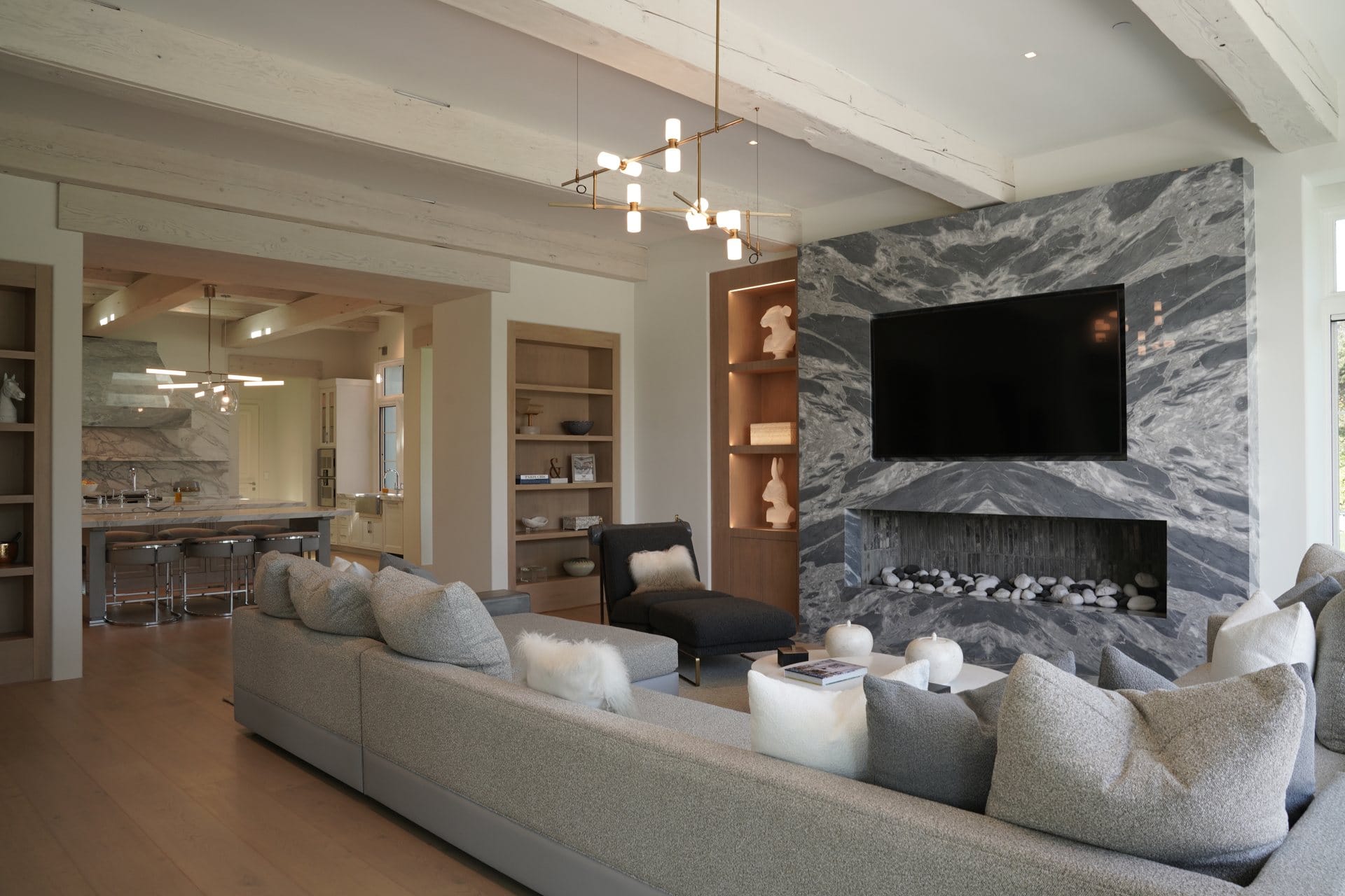 Modern living room with a marble fireplace wall and Sonance in-wall speakers hidden from view