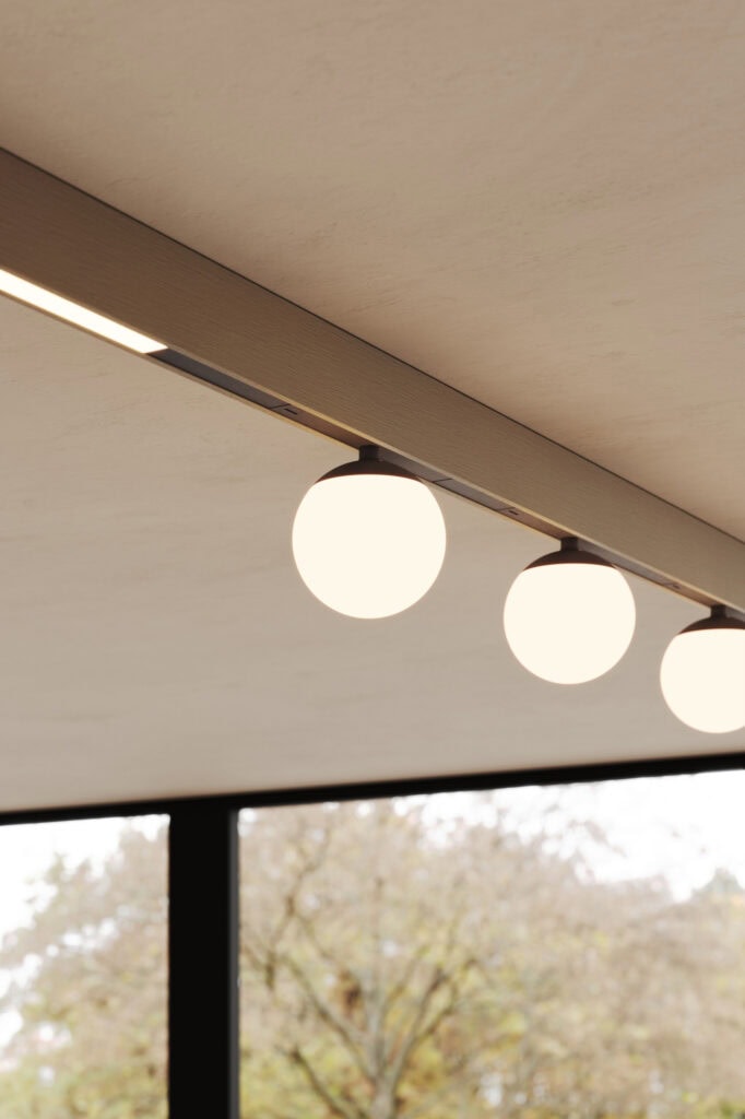 Modular Pista track with a linear light and globe pendants beside a window