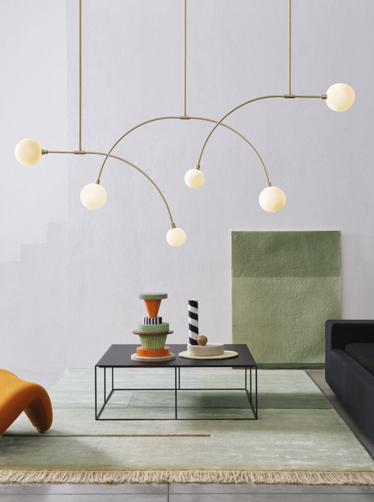 SkLO Balance 1.0 and 2.0 pendants in white glass above a living room seating area
